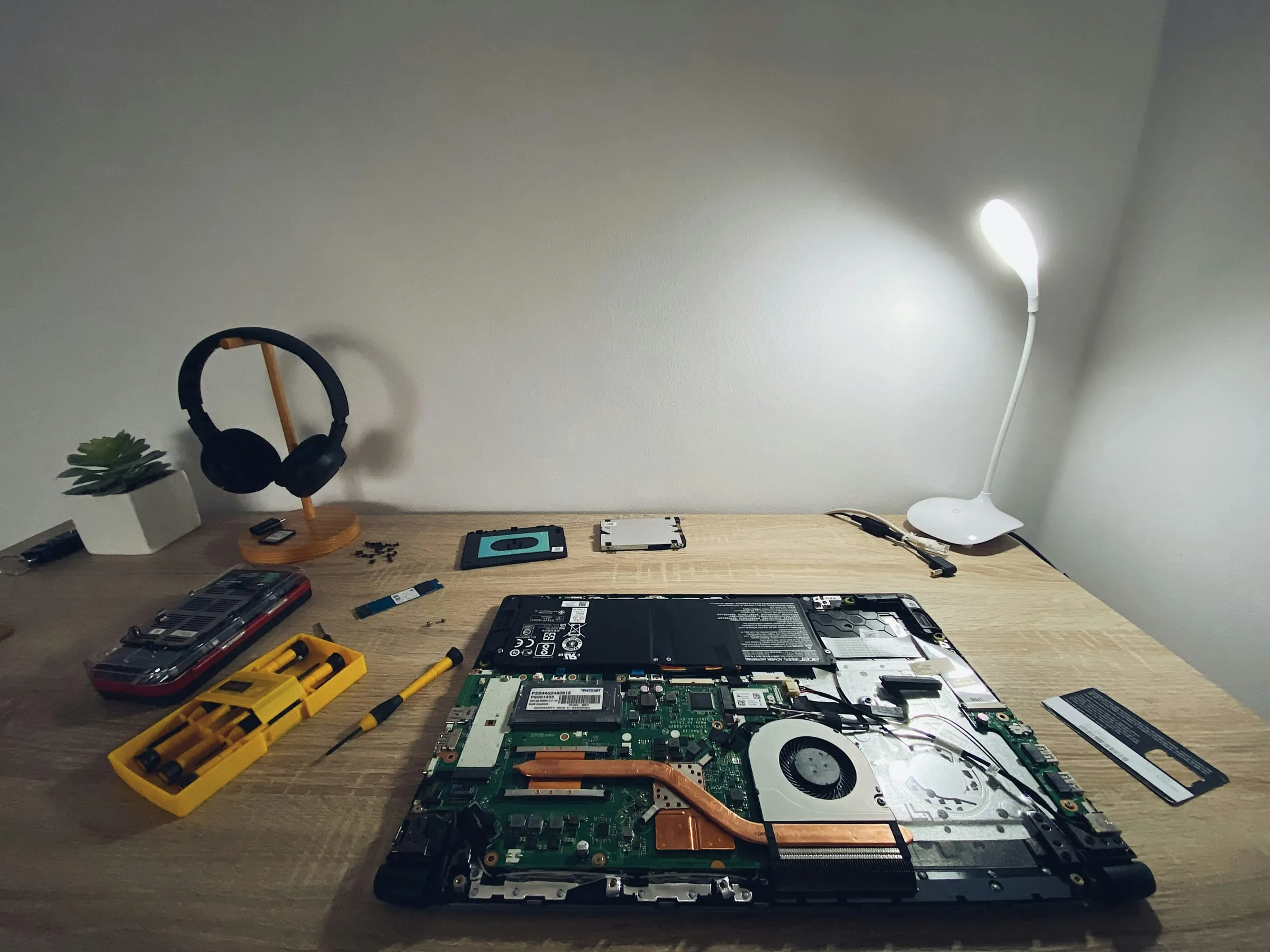 A service bench with an opened laptop and a set of tools