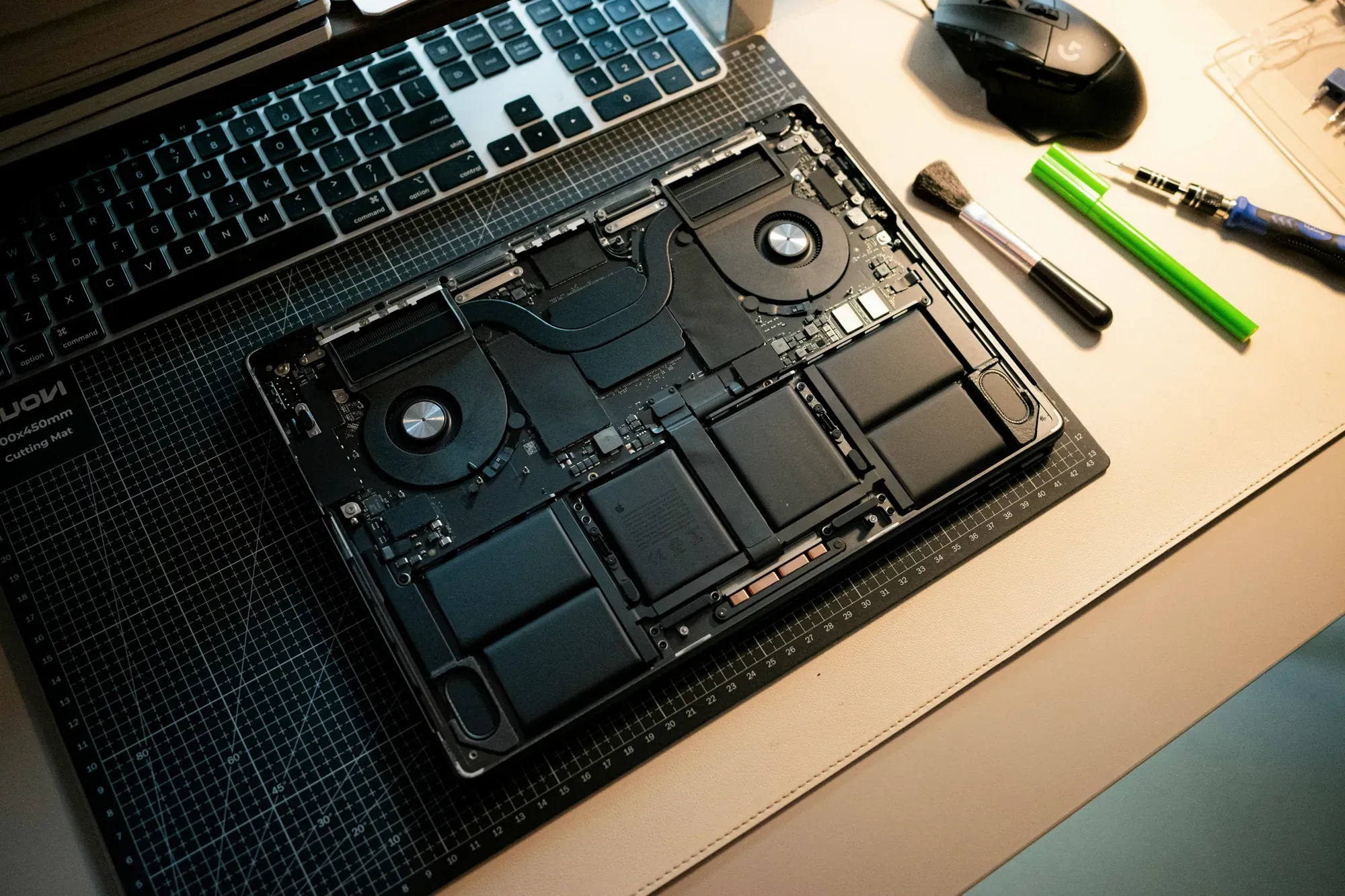 Otwarty laptop w trakcie serwisu, obok narzędzia