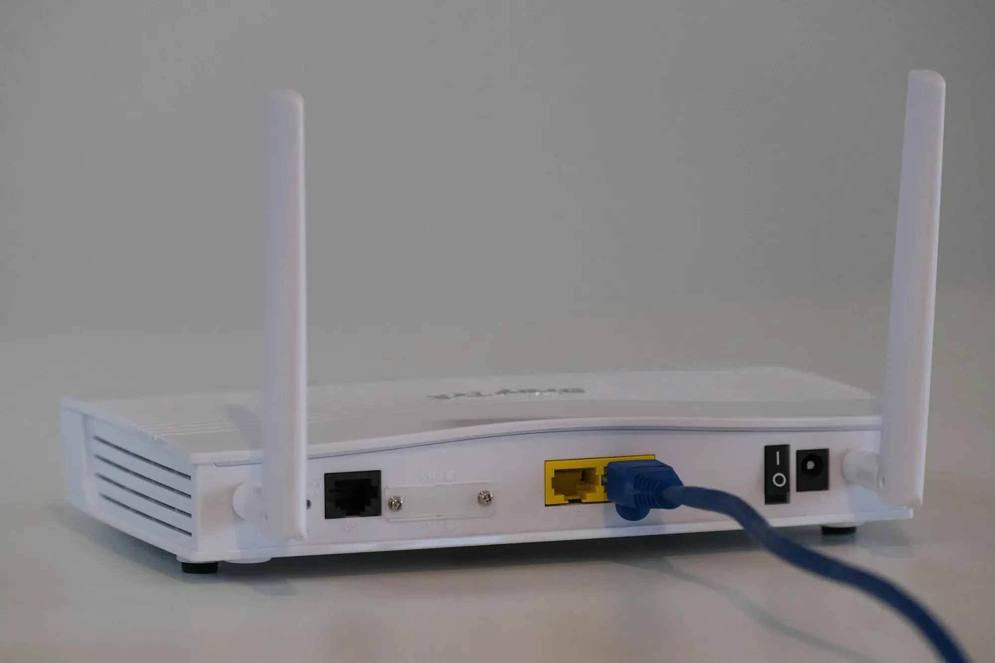 Biały router z antenami i podłączonym kablem