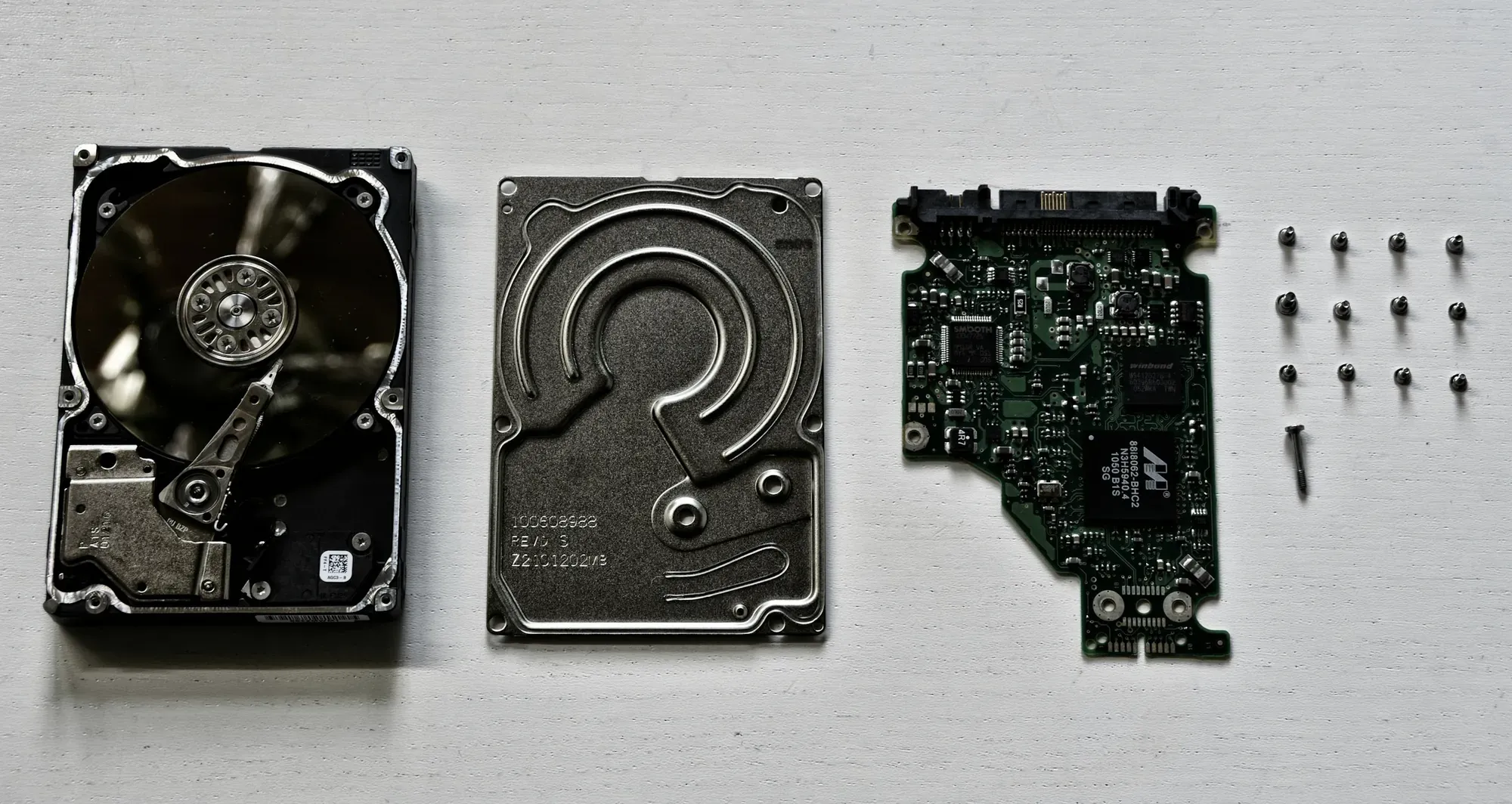 Rozebrany dysk twardy z obudową, talerzem i elektroniką
