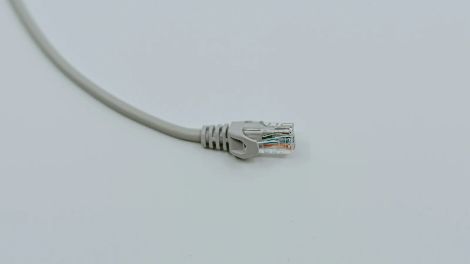 Zakończenie przewodu sieciowego wtykiem RJ45 na jasnym tle